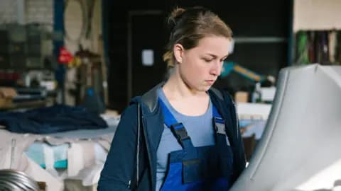 Getty Images Young woman working on a machine in an industrial setting