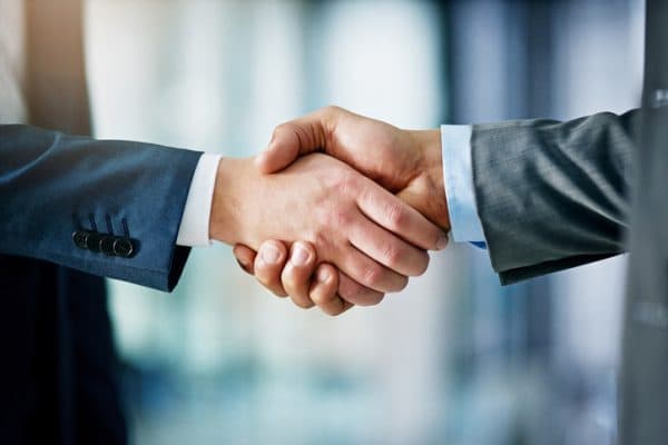 Handshake in an office by men in suits